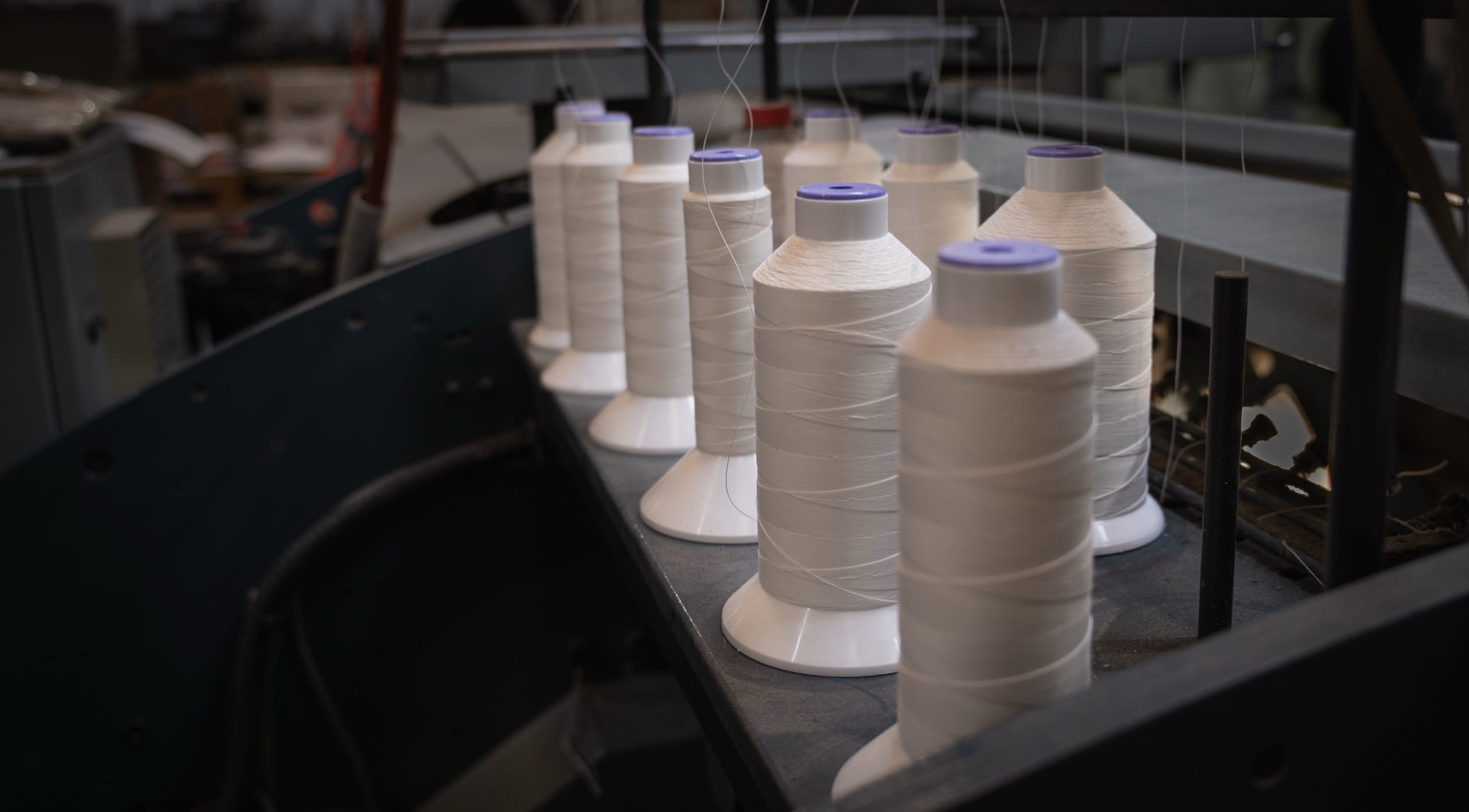 Cones of thread feeding the machine that Smyth-sews the be still journal in Melbourne
