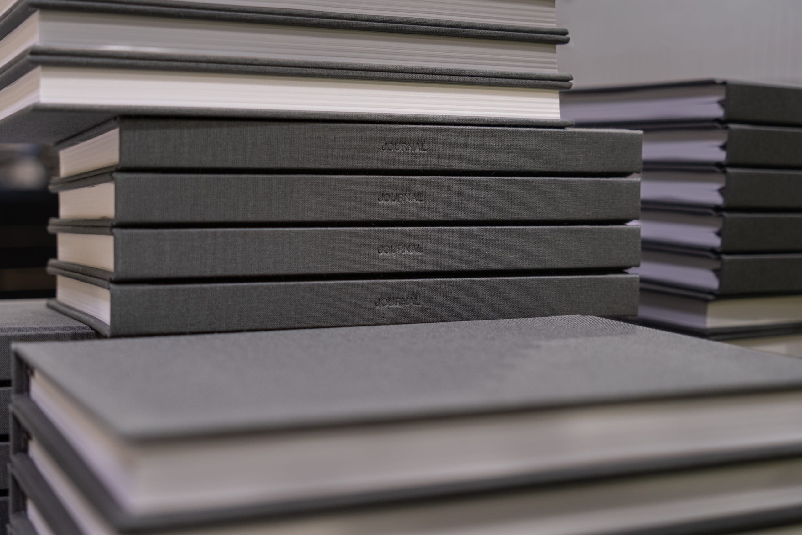 Finished be still journals in Slate stacked with JOURNAL debossed on the spine at the bindery