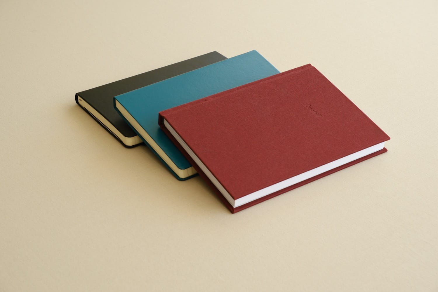 The be still journal closed beside a Moleskine and a Leuchtturm1917, the three notebooks from the paper comparison