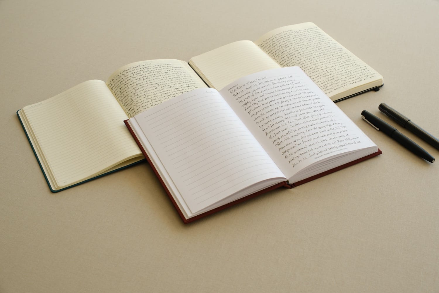 A be still journal, a Leuchtturm1917 and a Moleskine open side by side, showing the ruling and paper tone in a notebook paper weight comparison
